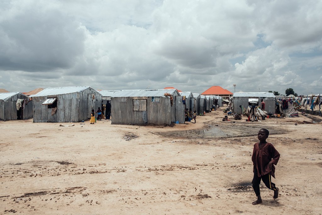 A child walks past shelters in a displacement camp in Maiduguri, Borno State, Nigeria.