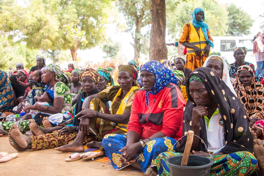 Local women and children in Yagoua, Cameroon, attend a community awareness event for the PULCCA project, aimed at combating food insecurity and building resilience.