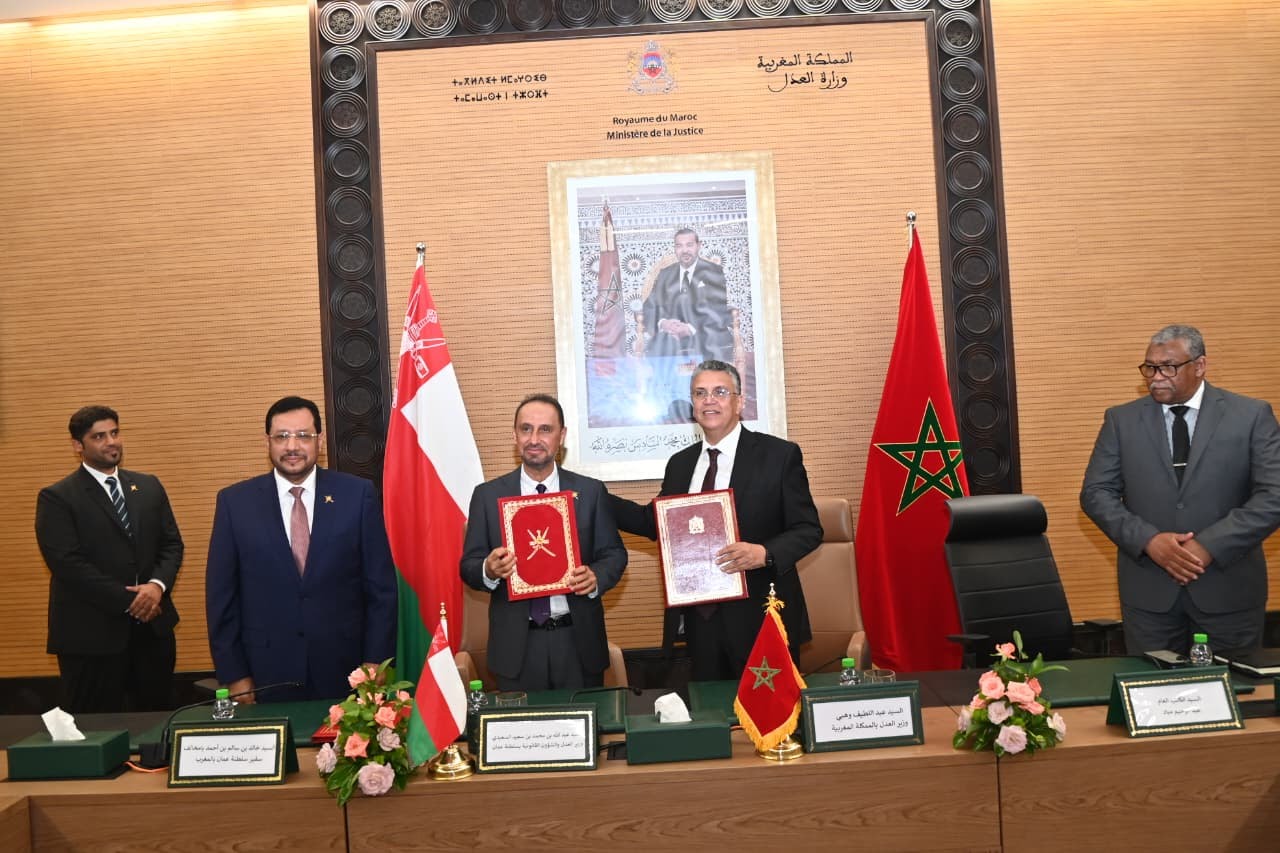 Moroccan and Omani officials signing a judicial cooperation agreement