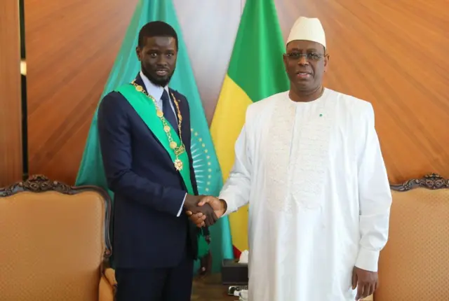 Le nouveau président sénégalais élu, Bassirou Diomaye Faye (à gauche), serre la main de l'ancien président sénégalais Macky Sall (à droite) lors d'une séance de photos après avoir prêté serment devant le Conseil constitutionnel, à l'issue de la cérémonie d'investiture à Dakar, au Sénégal, le 2 avril 2024. 