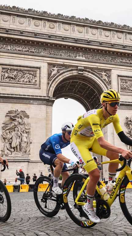 (FILES) This photograph taken on July 27, 2025, shows UAE Team Emirates - XRG team's Slovenian rider Tadej Pogacar wearing the overall leader's yellow jersey cycling with the pack of riders (peloton) past the Arc de Triomphe on Place Charles de Gaulle during the 21st and final stage of the 112th edition of the Tour de France cycling race, 132.3 km between Mantes-la-Ville and Paris' Champs-Elysees Avenue. Tour de France organisers announced on July 25, 2026 that they were shortening the 21st and final final stage of the 2026 edition due to the wildfires ravaging southwest France. The news came after the interior ministry had said that it would need to redeploy officers initially mobilised to provide security for the race, to areas affected by the fire. The 21st stage was due to last 133km and begin west of Paris in Thoiry. Instead, it will start on the Champs Elysees in Paris and take in a couple of extra laps around the famous avenue before joining the main Montmartre circuit, and will last only 89km. (Photo by Anne-Christine POUJOULAT / AFP) (ANNE-CHRISTINE POUJOULAT / AFP)