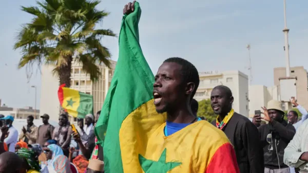 A protester holding anti-government slogans during a demonstration in Dakar, Senegal, March 6, 2026.