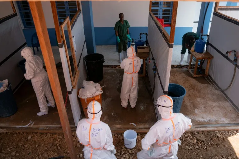 Healthcare workers in protective gear treating a patient